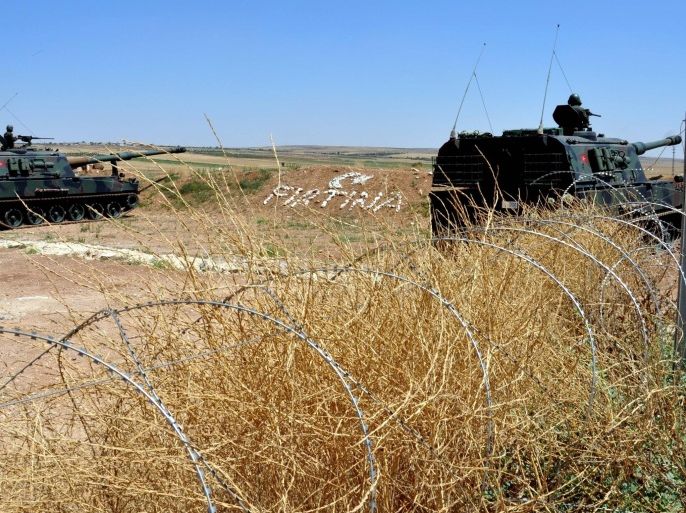 KILIS, TURKEY - JULY 01: Turkish soldiers stand guard on a self-propelled howitzer at the border between Turkey and Syria in Kilis's Elbeyli district, Turkey on July 01, 2015.