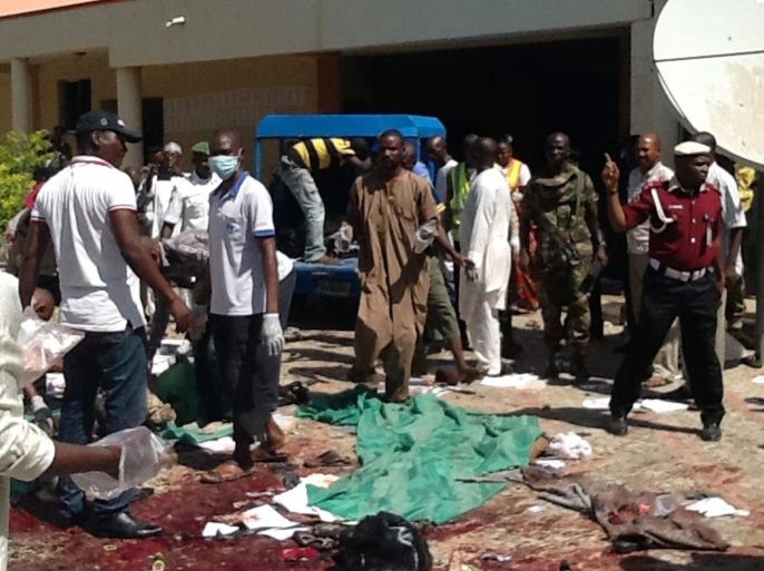 Members of the Jama'atu nasiril Islam first aid group, Red Cross helpers and security agents jointly search the scene for victims after a suicide bomber detonated a bomb at a local government building in the Sabon Gari district of the city of Zaria, Kaduna State, northern Nigeria, 07 July 2015. The suicide bomber reportedly entered a local government building as hundreds of civil servants were undergoing an identity check and detonated a bomb, killing at least 20 people. The blast was the latest in a string of attacks that have claimed more than 200 lives in Africa's largest economy in the past week alone. No group has yet claimed responsibility for the attack, but suspicion has been cast on Boko Haram, an extremist group which has killed more than 14,000 people since 2009 as it seeks to establish an Islamic state in northern Nigeria. EPA/STRINGER ATTENTION EDITORS: PICTURE CONTAINS GRAPHIC CONTENT * BEST QUALITY AVAILABLE