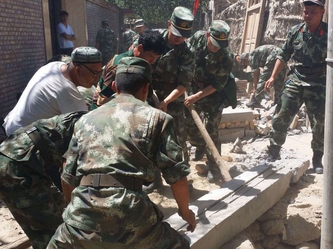 WH3531 - Hetian, Xinjiang, CHINA : Rescuers help villagers dismantle damaged walls after an earthquake hit the area in Pishan county in Hetian, northeast China's Xinjiang region on July 3, 2015. A shallow 6.4-magnitude earthquake struck China's far western region of Xinjiang, the US Geological Survey said, with at least six people killed according to Chinese officials. CHINA OUT AFP PHOTO
