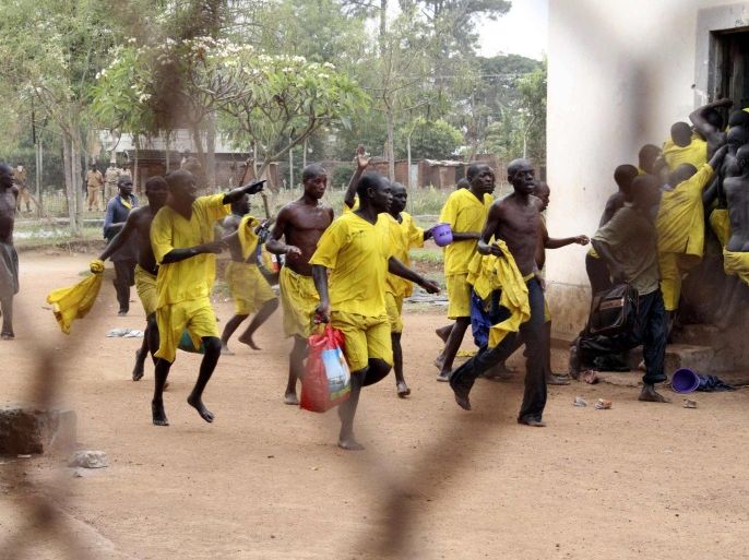 Prisoners runs towards their ward after their prison riot was quelled at the Lira Central Prison in Northern Uganda February 13, 2013. The prisoners rioted against the long periods in remand and congestion in wards, according to local media. Lira Central Prison was built in the 1930s to hold less than 100 prisoners but there are currently 680, with most of them on remand awaiting trial. Some prisoners have already been on remand for three years, according to the report. REUTERS/Hudson Apunyo (UGANDA - Tags: CRIME LAW CIVIL UNREST)