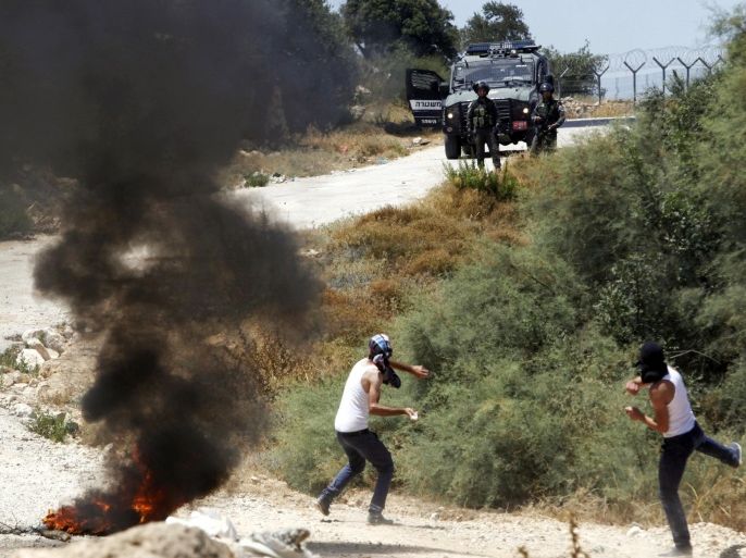 Palestinians hurl stones towards Israeli border police officers during a demonstration against the separation barrier, in the West Bank village of Beit Jallah, near Jerusalem, Sunday, Aug. 23, 2015. (AP Photo/Mahmoud Illean)