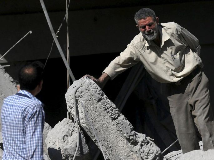 A man reacts amid rubble caused by what activists said was barrel bombs dropped by forces loyal to Syria's President Bashar Al-Assad in Douma, Eastern Al-Ghouta, near Damascus, Syria August 22, 2015. REUTERS/Bassam Khabieh