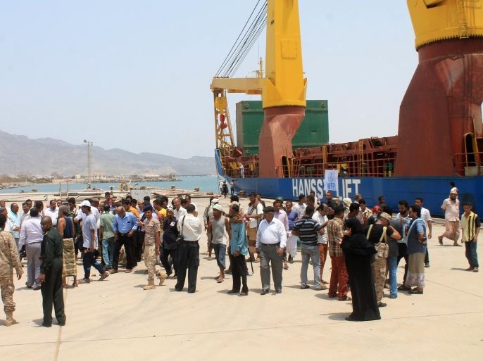 People gather in front of a UN's World Food Programme ship docked in Yemen's devastated port city of Aden on July 21, 2015 as it brings in desperately needed relief supplies after four months of fierce fighting between rebels and loyalist fighters. The humanitarian aid arrived as forces loyal to exiled President Abedrabbo Mansour Hadi pressed on with operations to tighten their control over the southern city. AFP PHOTO / STR