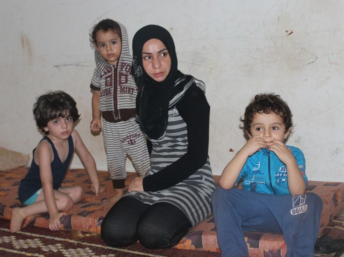 منال ناجي اللاجئة من حصار مخيم اليرموك بسوريا تتوسط أولادها - مخيم البداوي - شمال لبنان