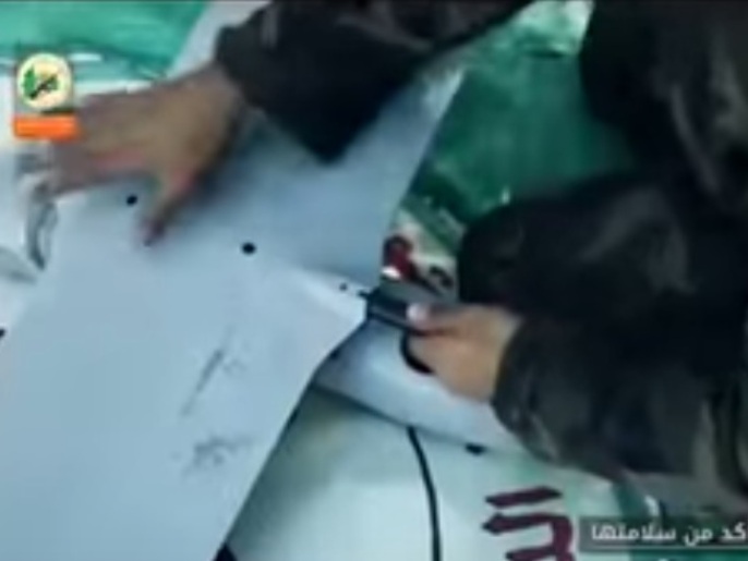 ‪أحد عناصر الهندسة في كتائب القسام يقوم بتجميع طائرة الاستطلاع الإسرائيلية‬ (الجزيرة)