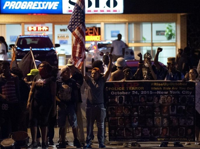 Protesters line West Florissant Avenue to mark the one-year anniversary of the death of Ferguson teenager Michael Brown Jr. in Ferguson, Missouri, USA, 10 August 2015. Protesters gathered to mark the one-year anniversary of the death of Ferguson teenager Michael Brown during an altercation with former Ferguson police officer Darren Wilson. Local authorities declared a state of emergency on 10 August 2015 in the wake of violence that erupted in Ferguson, Missouri on the anniversary of the shooting death of unarmed African-American teenager Michael Brown by a white police officer.