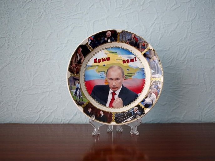 A plate with a picture of Russian President Vladimir Putin and the phrase "Crimea is ours" is seen in in this photo illustration taken in a hotel room in Kazan, Russia, July 24, 2015. He may be in charge of an economy in crisis, but if mobile phone covers and souvenir mugs are a barometer of popularity, Russian President Vladimir Putin need not fear for his political future. In fact, Moscowâ€™s annexation of Crimea from Ukraine last year has given the memorabilia makers even more material to glorify, sometimes wryly, a president whose image as a champion of Russian national interests in a hostile world is barely challenged in his own country. REUTERS/Stefan WermuthTHE IMAGES SHOULD ONLY BE USED TOGETHER WITH THE STORY - NO STAND-ALONE USES. PICTURE 2 OF 17 FOR WIDER IMAGE STORY "FROM RUSSIA WITH LOVE"SEARCH "WERMUTH PUTIN" FOR ALL PICTURES