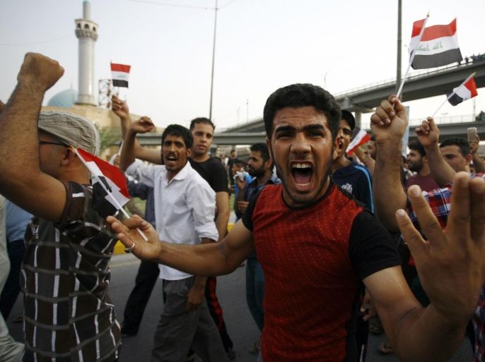 An Iraqi man shouts slogans and waves his national flag during a demonstration against corruption and poor services on August 7, 2015 in the holy city of Najaf. Several thousand demonstrators turned out in Baghdad and the south to protest rampant corruption and abysmal electricity services that plague Iraq, calling for officials to be held to account. AFP PHOTO / HAIDAR HAMDANI