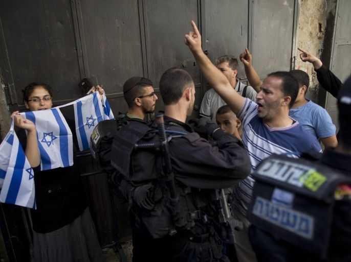 Israeli border police stand guard as a right-wing Jewish girl from the 'Students for the Temple Mount' movement (L) holds an Israeli flag and Palestinians muslims shout 'God is great' in Arabic and 'Al-Aqsa is ours', at the entrance to the Al-Aqsa mosque compound in the Old city of Jerusalem, Israel, 09 August 2015. Tension escalates at the al-Aqsa compound as more Jewish right-wing extremists are trying to pray inside the compound. The area houses the mosque, considered the third-holiest site in Islam, but it is also the site of the ruins of the biblical Jewish temple and is the most sacred site in Judaism.