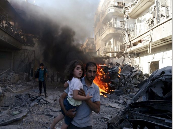 A man carries a girl as they rush away from a site hit by what activists said were airstrikes by forces loyal to Syria's President Bashar al-Assad in the Douma neighborhood of Damascus, Syria August 24, 2015. REUTERS/Bassam Khabieh