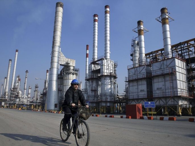 In this Dec. 22, 2014 photo, an Iranian oil worker rides his bicycle at the Tehran oil refinery, south of the capital Tehran, Iran. While it will likely be months before sanctions on Iran ease, business and political leaders are wasting no time in trying to tap into a large and what they hope will be a lucrative Iranian market. Ads for European cars and luxury goods are starting to reappear in Tehran. American firms, though, have to be much more cautious. Deal or no deal, U.S. sanctions not related to the nuclear program will still be in place and bar most American companies from doing business with Iran.(AP Photo/Vahid Salemi)