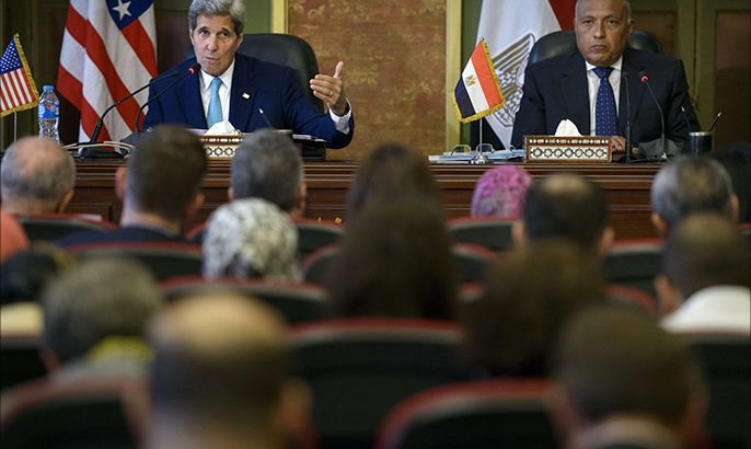 Egypt's Foreign Minister Sameh Shoukry (R) listens as US Secretary of State John Kerry delivers a speech during a press conference after meetings at the Ministry of Foreign Affairs on August 2, 2015 in Cairo. Kerry will meet Egyptian President Abdel Fattah al-Sisi in Cairo to relaunch strategic talks, on a regional mini-tour to sell the Iran nuclear deal to sceptical allies. AFP PHOTO / POOL / BRENDAN SMIALOWSKI