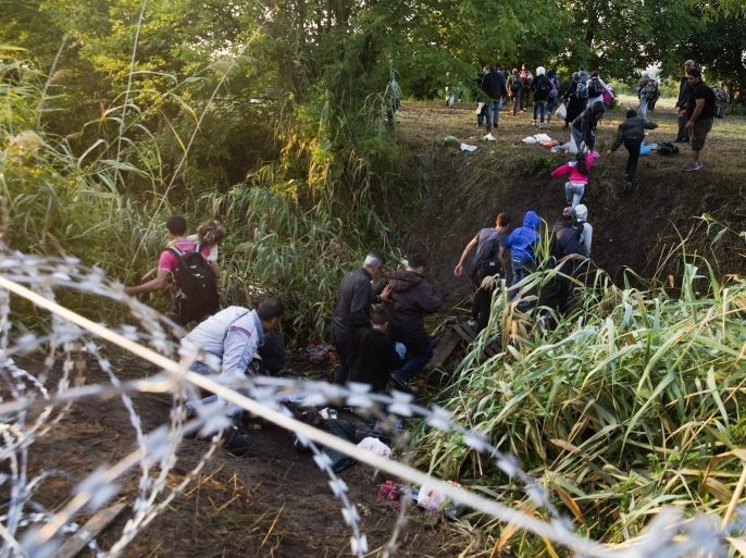Another group of migrants manage to scramble through the razor wire fencing at the border between Hungary and Serbia near Roszke, 180 kms southeast from Budapest, Hungary, 27 August 2015. EPA/Zoltan Balogh HUNGARY OUT