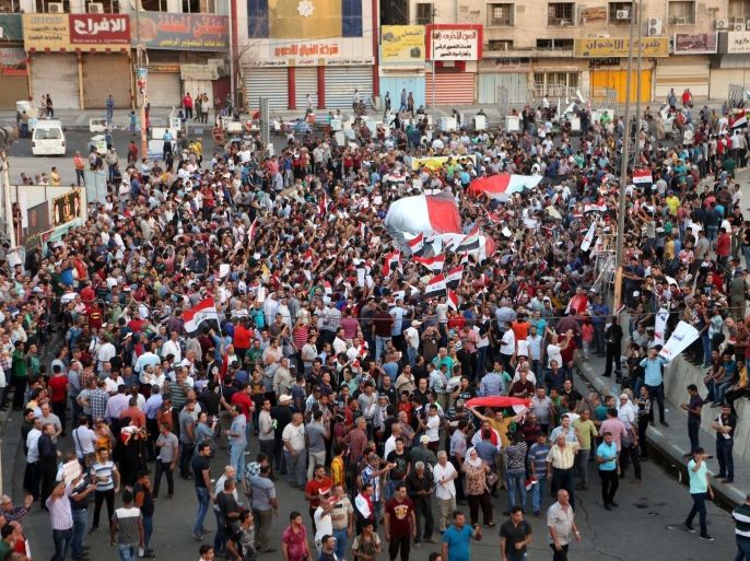 Demonstrators chant in support of Iraqi Prime Minister Haider al-Abadi as they wave national flags during a demonstration at Tahrir Square in Baghdad, Iraq, Sunday, Aug. 9, 2015. Iraq's prime minister unveiled a bold plan Sunday to abolish three vice presidential posts and the offices of three deputy premiers, hoping to cut spending amid mass protests against his government as the Islamic State group still holds a third of his nation. (AP Photo/Khalid Mohammed)
