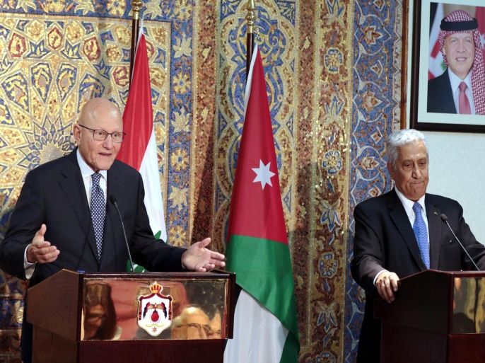 Lebanese Prime Minister Tammam Salam (L) gestures during a press conference with his Jordanian counterpart Abdullah Nsur in the Jordanian capital Amman on August 12, 2015. A portrait of Jordan's King Abdullah II is seen in the background. AFP PHOTO / KHALIL MAZRAAWI