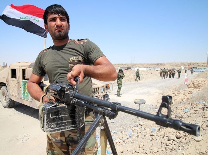 A fighter from the Popular Mobilisation units holds a weapon on the front line during a military operation against Islamic State (IS) group jihadists on the road leading to Saqlawiya, north of Fallujah, in Iraq's Anbar province on August 19, 2015. Iraqi Prime Minister Haider al-Abadi approved an investigative commission's recommendation that commanders face military justice and probable trial for withdrawing from Ramadi without orders in May. AFP PHOTO / HAIDAR MOHAMMED ALI