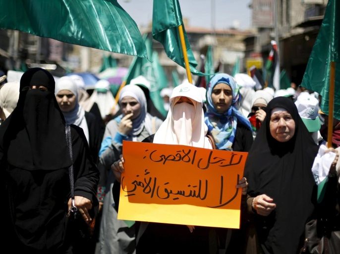 Protesters from the Islamic Action Front wave their party flags and shout slogans during a protest in support of Palestinians and against the violence that occurred at al-Aqsa Mosque, after Friday prayers in Amman, Jordan July 31, 2015. Masked rock-throwing Palestinians and Israeli police using stun grenades clashed on Sunday at al-Aqsa mosque plaza, on the annual Jewish day of mourning for Jerusalem's two destroyed Biblical temples. The placard reads: 'For al-Aqsa, no for security coordination'. REUTERS/Muhammad Hamed