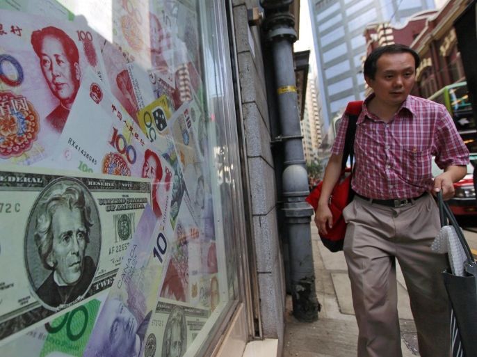 (FILE) A file photo dated 13 September 2010 showing a man walking past oversized Chinese yuan (RMB) notes, US bank notes and other foreign currency seen out side a foreign exchange in Hong Kong, China. China's central bank on 12 August 2015 devalued the yuan for the second time in two days, to aid a slowing economy. The People's Bank of China unexpectedly adjusted its daily reference exchange rate by a further 1.6 per cent, setting it at 6.3306 to the US dollar. On 11 August, the bank cut the rate by 1.9 per cent, triggering the biggest one-day slide in yuan value against the dollar since China unified official and market exchange rates in 1994. EPA/YM YIK *** Local Caption *** 02333459