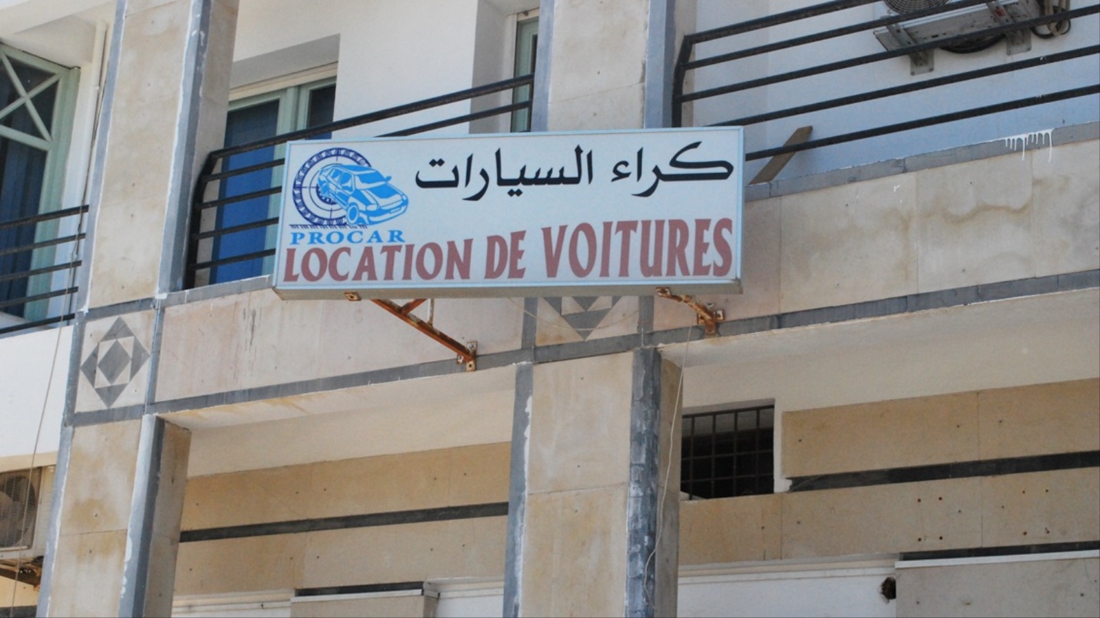 لافتة في أحد شوارع العاصمة تونس تشير إلى محل لتأجير السيارات (الجزيرة)