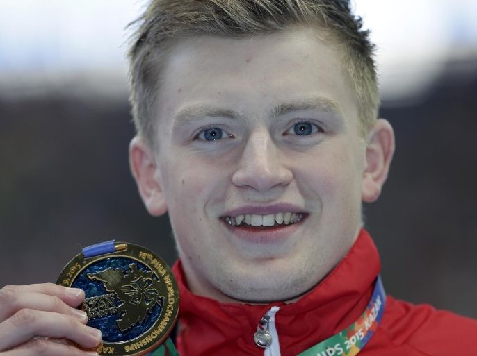 Britain's Adam Peaty holds his gold medal up after winning the men's 100m breaststroke final at the Swimming World Championships in Kazan, Russia, Monday, Aug. 3, 2015. (AP Photo/Michael Sohn)