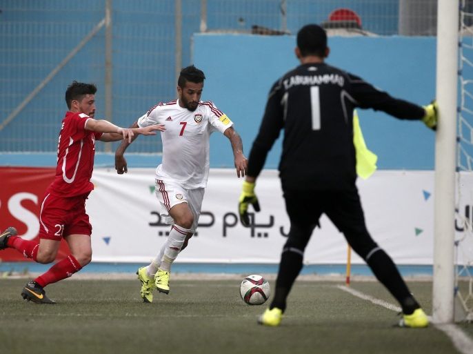 TCX008 - AL-RAM, WEST BANK, - : UAE's forward Ali Mabkhout (C) vies for the ball with Palestinian defender Saeed Musabbeh (L) during the 2018 FIFA World Cup qualifying football match between Palestine and UAE, at the Faisal al-Husseini Stadium, on September 8, 2015 in the West Bank town of Al-Ram. AFP PHOTO / THOMAS COEX
