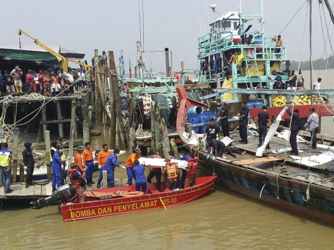 A handout photograph released by the Malaysian Maritime Enforcement Agency on 03 September 2015 showing a body of an Indonesian capsized boat victim carried by Malaysian rescuers at Hutan Melintang jetty in Perak, Malaysia, 03 September 2015. At least 14 people drowned and 19 has been rescued after a boat carrying up to 100 people sank off the coast of Malaysia.