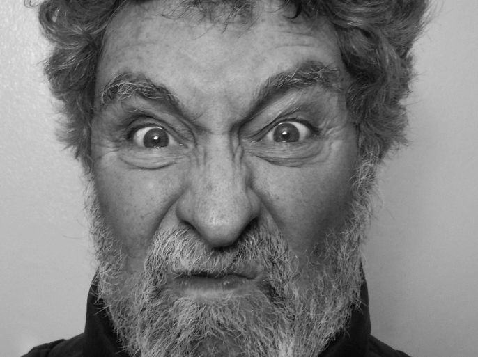 White Man, age 64, angry or frustrated expression in extreme close-up of face. Black and white