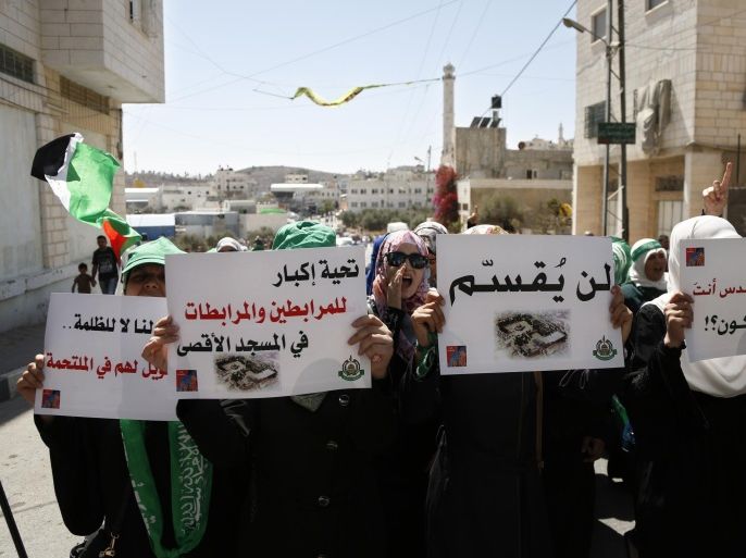 Palestinian protesters hold signs during a demonstration in the West Bank city of Hebron, Friday, Sept. 18, 2015. Israel called up a few hundred border police reservists on Friday to beef up security following Palestinian riots at Jerusalem's most sensitive holy site and outbreaks of violence elsewhere in the city that claimed the life of an Israeli and injured others this week. Arabic on the signs from right to left read, "If your are not for Quds, who will be?," "It will not be divided," "A big shout out to those holding steadfast at Aqsa Mosque." (AP Photo/ Nasser Shiyoukhi)