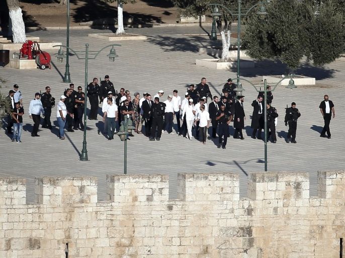 Israeli police escort a group of Jewish visitors walking at the Al-Aqsa mosque compound in Jerusalems old city, on September 28, 2015. New clashes broke out between Israeli police and Palestinians at Jerusalem's flashpoint Al-Aqsa mosque compound, with further trouble feared in the week ahead as Jews celebrate the Sukkot holiday. AFP PHOTO / THOMAS COEX
