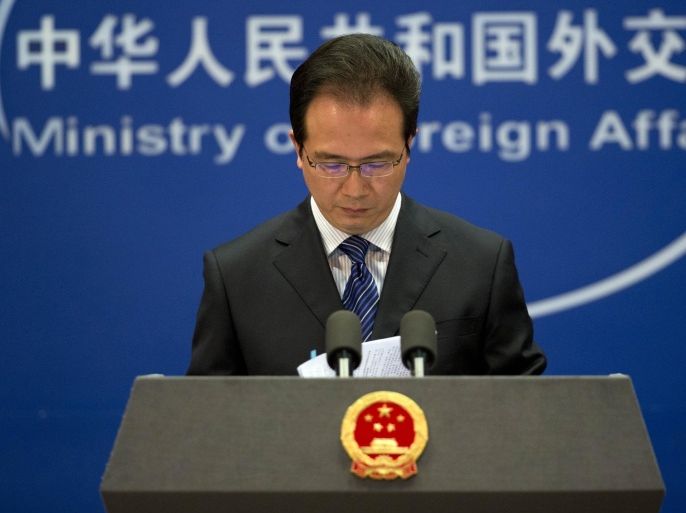 Foreign ministry spokesman Hong Lei looks at the papers before he speaks during a daily briefing at the Ministry of Foreign Affairs office in Beijing, China Tuesday, May 20, 2014. China on Tuesday warned the United States was jeopardizing military ties by charging five Chinese officers with cyberspying and tried to turn the tables on Washington by calling it "the biggest attacker of China's cyberspace." (AP Photo/Andy Wong)