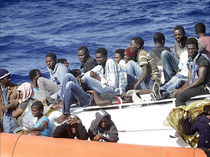 epa04938805 Some of the rescued migrants sit on the deck of the Italian Coast Guard boat, during a rescue operation in the Mediterran Sea, 19 September 2015. Migrants are being rescued as part of the Mare Nostrum operation that Italy launched after some 400 migrants died in two separate boat disasters in October 2013. Italy is struggling to cope this year with a huge increase in the already big flow of migrants to attempt the hazardous crossing from North Africa. EPA/GIUSEPPE LAMI