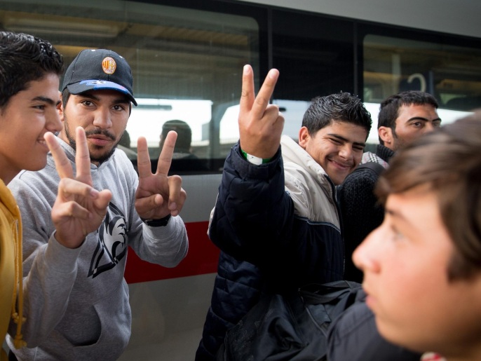 لاجئان يرفعان علامة النصر لدى وصولهما إلى محطة القطارات في ميونيخ (الأوروبية)