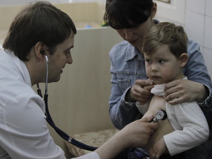 In this Monday, April 23, 2013 photo pediatrician Fyodor Lapiy examines a child before administering him a combined vaccine against diphtheria, whopping cough and tetanus in Children's Hospital No. 1 in Kiev,Ukraine. Only about one-half of Ukraine s children are fully immunized against vaccine-preventable communicable diseases in line with local health regulations, compared to over 90 percent in Western Europe, according to UNICEF, the United Nations children s agency. Such a low immunization rate has already led to a major outbreak of measles and a risk of an outbreak of polio, a highly dangerous disease which may cause paralysis and which has been unseen in Ukraine for more than a decade, UNICEF and the World Health Organization said ahead of the current World Immunization week.
