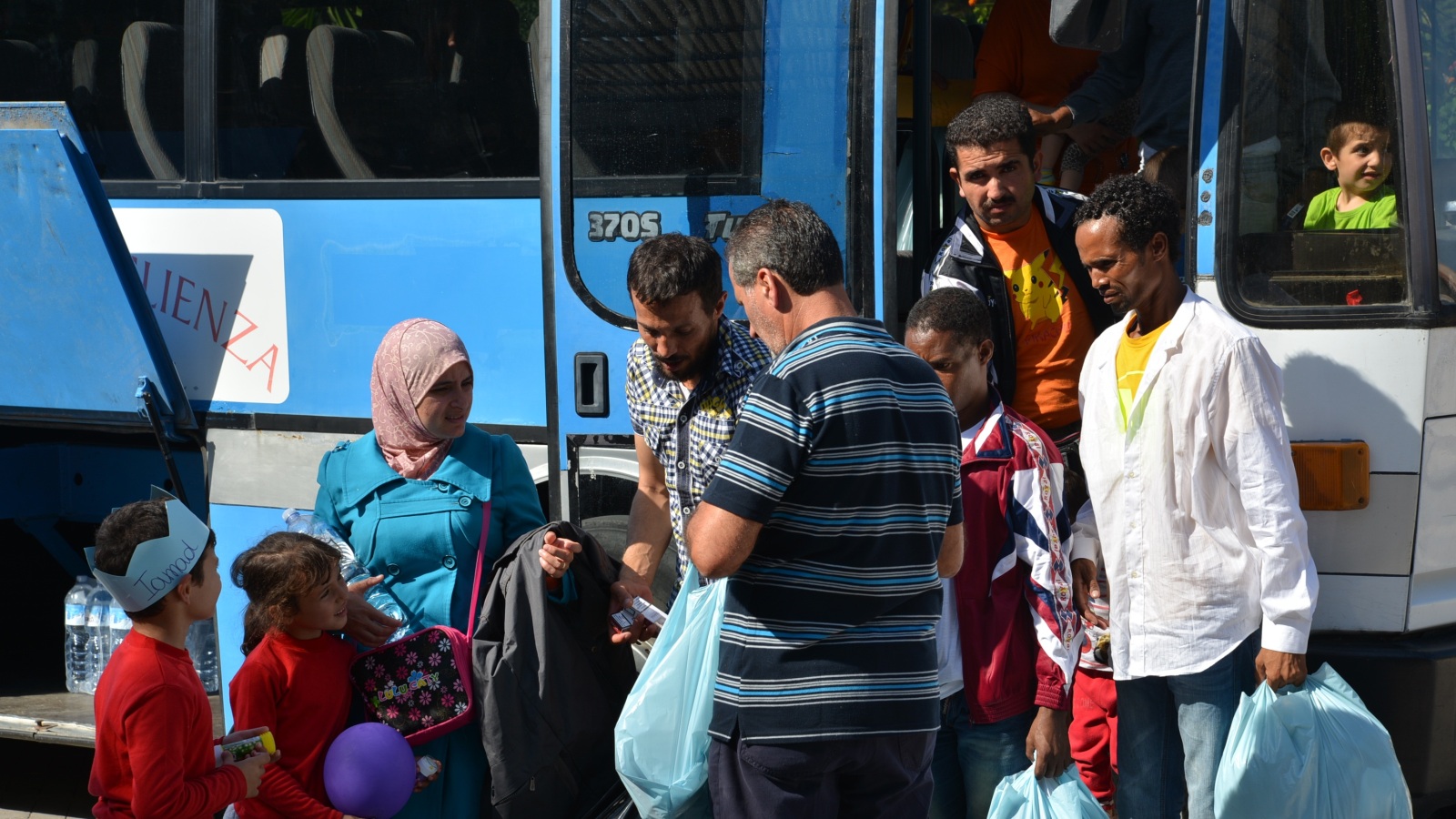 لاجئون سوريون وإريتريون عند وصولهم لمعسكر اللجوء بجزيرة لامبيدوزا الإيطالية(الجزيرة)