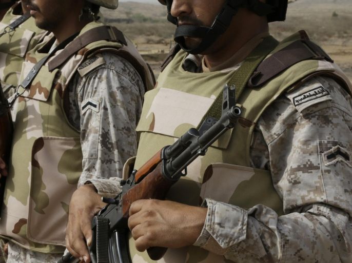 In this photo taken on April 20, 2015, Saudi soldiers with their weapons stand guard at the Yemen border in Jizan, Saudi Arabia. The country is now leading an offensive against the Shiite Houthi rebels in Yemen, who are supported by its arch-rival Iran. Much of the kingdom, however, continues on its prosperous way, as reflected in interviews by The Associated Press with more than two dozen people. (AP Photo/Hasan Jamali)