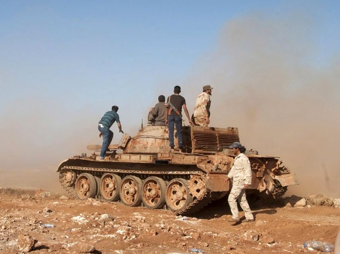 Members of the Libyan pro-government forces stand on a tank during their deployment in the Lamluda area, southwest of the city of Derna, Libya, June 16, 2015. Picture taken June 16, 2015. REUTERS/Stringer