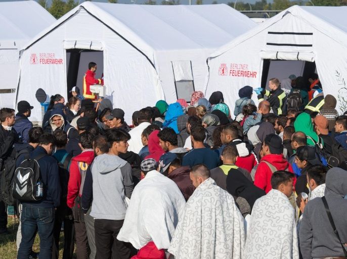 Refugees who arrived at Schoenefeld train station wait for medical treatment in front of a tent of the Berlin fire brigade, in Schoenefeld, Germany, 10 September 2015. Germany can deal with the arrival of hundreds of thousands of refugees without cutting social welfare benefits or raise taxes, Vice Chancellor Sigmar Gabriel said on 10 September, during a debate in parliament on next year's budget. Germany expects 800,000 asylum seekers this year, four times more than last year and more than any other country in the European Union, which is split on how to deal with the biggest refugee crisis since World War II.