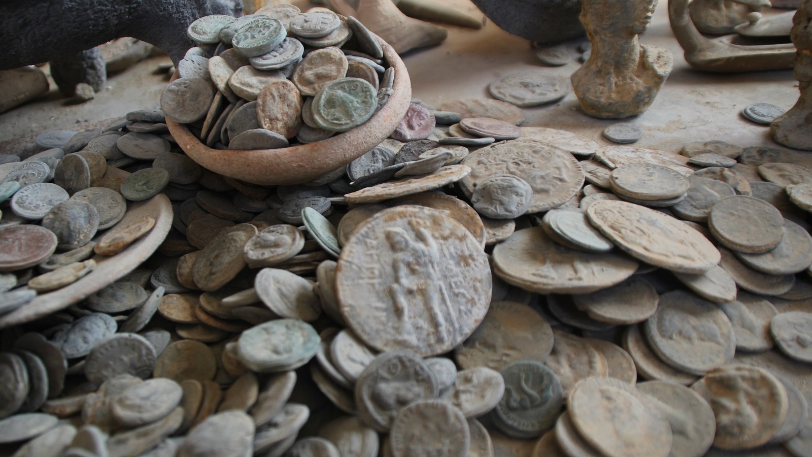 ‪نقود تاريخية مقلدة مصنوعة من الفخار والمعدن‬ (الجزيرة)