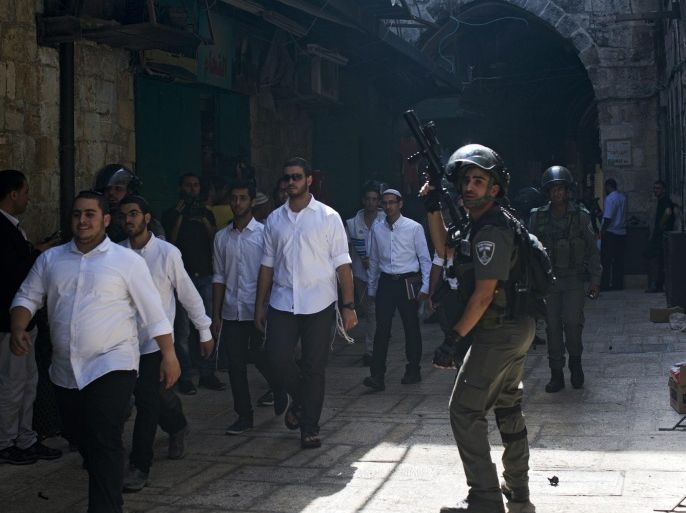 Israeli border Police guarding religious Jews passage in the alleys lead to Al-Aqsa mosque compound in the old City of Jerusalem, during the visit of Jews and tourism to Al-Aqsa mosque compound, also called the Temple Mount, in the third day of the Jewish New Year holiday, 15 September 2015. High tension surround in the Old City of Jerusalem, Israeli police spokesman report that of five Israeli policemen lightly wounded from firework thrown by Palestinian protesters inside the Al-Aqsa mosque compound, and two Palestinian where arrested.