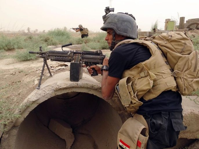In this Tuesday, Sept. 1, 2015 photo, Iraq's Special Weapons and Tactics Team (SWAT) with U.S.-made weapons, prepare to attack Islamic State Group militants at the front line in the south suburbs of Ramadi, Anbar province, Iraq. (AP Photo)