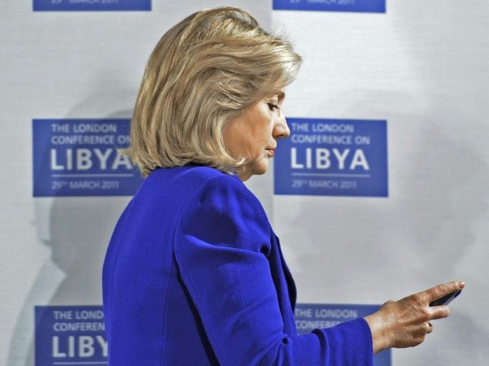 Former U.S. Secretary of State Hillary Clinton checks her mobile phone before a conference at the Foreign & Commonwealth Office in London, in this March 29, 2011 file photo. An investigative committee in the U.S. House of Representatives will subpoena Clinton's personal emails regarding the 2012 attack on the U.S. consulate in Benghazi, Libya, the Washington Post reported on March 4, 2015. REUTERS/Stefan Rousseau/File Pool (BRITAIN - Tags: POLITICS CONFLICT)