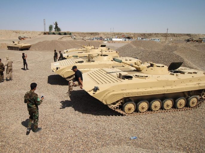 Members of the allied Iraqi forces consisting of the Iraqi army and fighters from the Popular Mobilisation units gather around tanks on the front line during a military operation against Islamic State (IS) group jihadists on the road leading to Saqlawiya, north of Fallujah, in Iraq's Anbar province on August 19, 2015. Iraqi Prime Minister Haider al-Abadi approved an investigative commission's recommendation that commanders face military justice and probable trial for withdrawing from Ramadi without orders in May. AFP PHOTO / HAIDAR MOHAMMED ALI