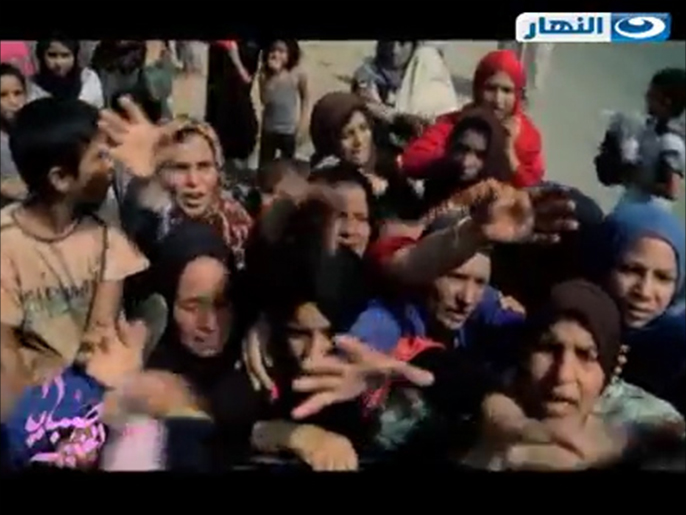 اللاجئون السوريون يتهافتون على المساعدات الغذائية التي حملتها ريهام سعيد (الجزيرة)