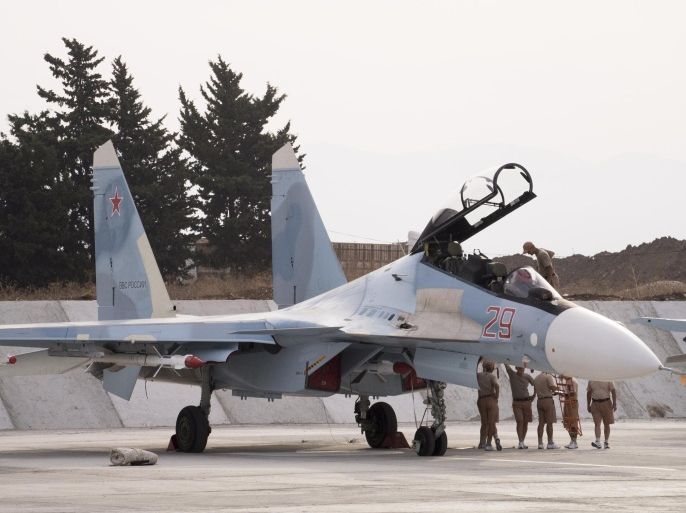 In this photo taken on Thursday, Oct. 22, 2015, Russian air force personnel stand near a Russian war plane at Hemeimeem airbase, Syria. Nearly a quarter of a century after the Soviet collapse, the air campaign in Syria has proven that the resurgent Russian military machine could again operate far away from the nation's borders. (AP Photo/Vladimir Isachenkov)