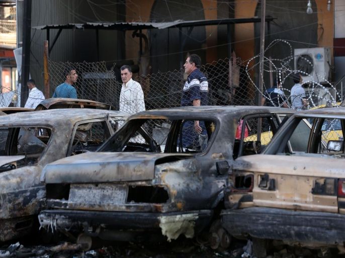 Civilians inspect the aftermath of a car bombing near a restaurant in a commercial area of central Baghdad, Iraq, Tuesday, Sept. 29, 2015. Iraqi officials say a car bomb exploded around midnight Monday in central Baghdad killing and wounding civilians. (AP Photo/Hadi Mizban)