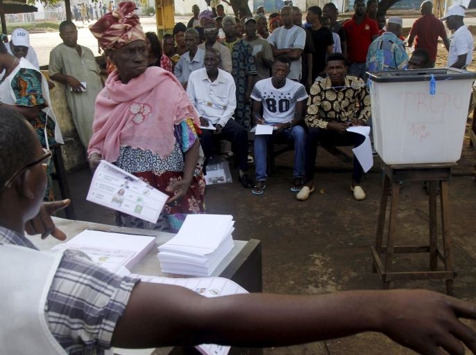 A woman prepares to cast her vote at a polling station during a presidential election in Conakry, Guinea October 11, 2015. REUTERS/Luc Gnago