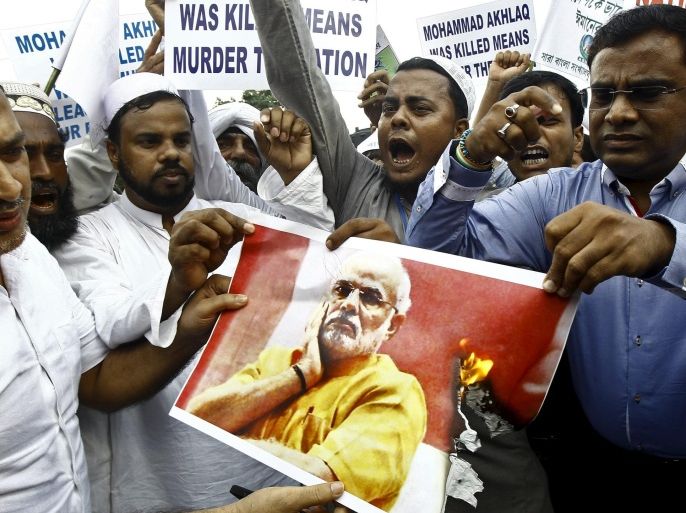 Demonstrators shout slogans as they burn a portrait of India's Prime Minister Narendra Modi during a protest in Kolkata, India, October 14, 2015. Modi has condemned the murder of a Muslim man over rumors he ate beef, in his first response to an incident that has sparked concern about growing religious intolerance. Many among India's majority Hindu community regard cows as holy, but beef is widely eaten by Hindus in parts of the south, as well as those of lower castes and minority Muslims and Christians. REUTERS/Rupak De Chowdhuri