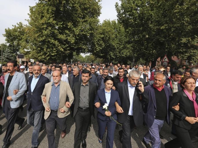 Selahattin Demirtas, centre, and Figen Yuksekdag, to his left, co-leaders of the pro Kurdish Democratic Party of Peoples (HDP) lead a march towards the site of Saturday's explosions in Ankara, Turkey, Sunday Oct. 11, 2015. Turkey declared three days of mourning following Saturday's nearly simultaneous explosions that targeted a peace rally in Ankara to call for increased democracy and an end to the renewed fighting between the Turkish security forces and Kurdish rebels. (AP Photo/Burhan Ozbilici)