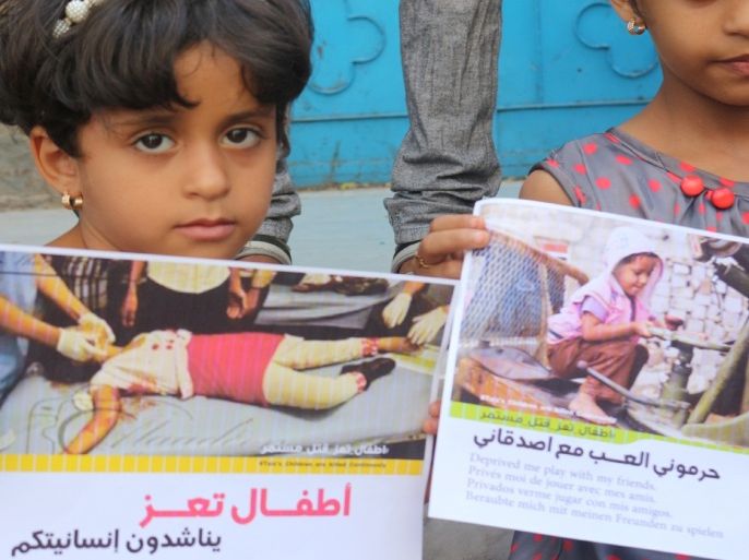 طفلتان ترفعان لافتات تناشد العالم التحرك لإنقاذهم خلال وقفة احتجاجية بشارع جمال وسط مدينة تعز اليمن الأحد 11 أكتوبر 2015