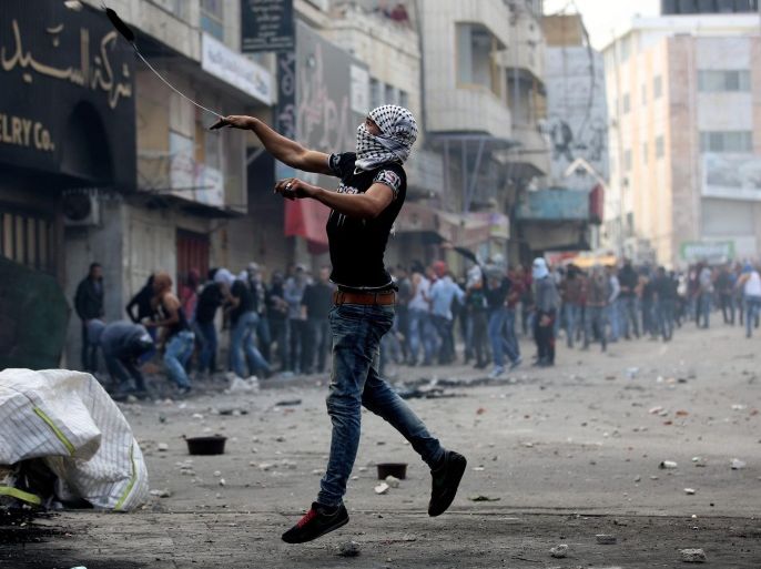 A Palestinian protesters throws stones during clashes with members of the Israeli armed forces in the West Bank city of Hebron, 09 October 2015. Israeli soldiers killed four Palestinians in clashes on the border with the Gaza Strip, while there were four stabbing incidents inside Israel targeting both Jews and Palestinians. Violence has been ongoing for weeks, focused on Jerusalem and nearby areas on the West Bank amid rising concerns the situation could lead to an even greater escalation if not scaled back soon.